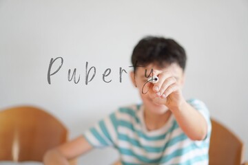 puberty concept. teenage boy writing the word with a marker pen on the screen.