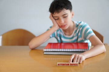 attention deficit. medical concepts. adolescent boy with some books and notebooks, bored. adhd.