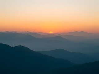 Fototapeta premium Stunning Mountain Sunset with Silhouetted Ridges and Vibrant Orange Sky - Scenic Landscape Photography.
