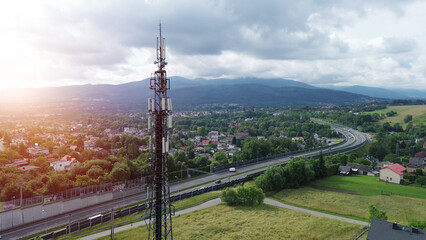 High antenna tower in rural town with scenic highway view