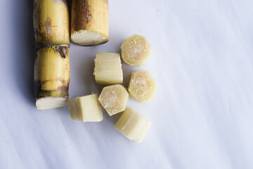 A bunch of sugar cane is cut into small pieces