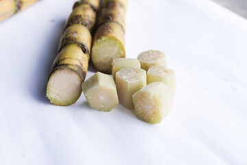 A bunch of sugar cane is cut into small pieces