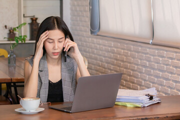 Asian beautiful businesswoman stressed reviewing documents in café diligently, concentrating on work while surrounded by coffee cups and paperwork insurance waiting for customer planning calculation