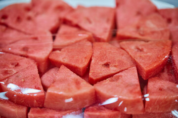 Close-up of chopped ripe watermelon on a plate wrapped with plastic bag