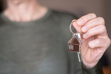 Real estate agent is holding new house keys, symbolizing property purchase, sale, or rental,...
