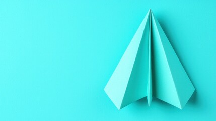Paper airplane on a vibrant turquoise background