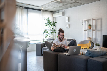 Freelancer working from home watching streaming movie on laptop and eating popcorn