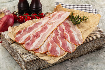 Sliced pork bacon over board