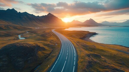 Fototapeta premium Scenic sunset over winding road and majestic mountains at coastal landscape