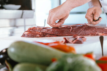 Professional Butcher Cutting Fresh Meat on a Wooden Board