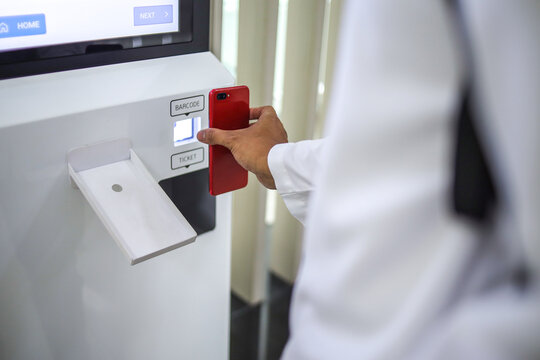 Close-up of Passenger Scanning Electronic Ticket from Smartphone on Self Service Check-in Machine at The Airport Terminal