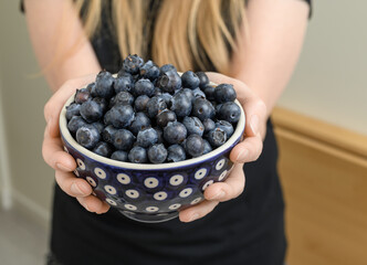 Miska pełna świeżych owoców, borówka amerykańska w dloniach © Paweł Kacperek