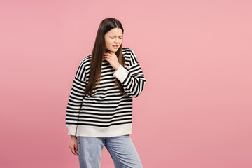 Upset, unhappy girl suffering from sore throat on pink background