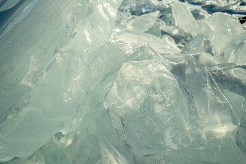Transparent block of ice in the rays of the sun at sunset. Winter natural abstraction of Baikal ice