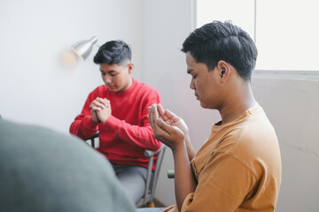 Obraz premium Close Up Of Young Asian Man Praying Together Before Activity