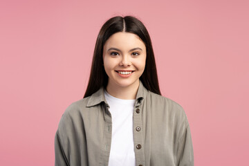 Fototapeta premium Young latin girl smiling on pink background: casual portrait of a cheerful teenager