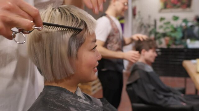 Hairdresser cutting blonde hair in slow motion