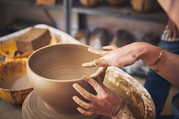 Hands, clay and bowl on pottery wheel for sculpture mold, manufacturing process and creative...