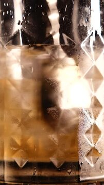 stearing the beer with spoon with black bakground