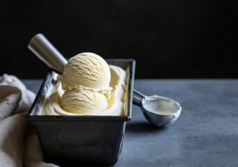 Creamy vanilla ice cream scoops in a metal container ready to serve