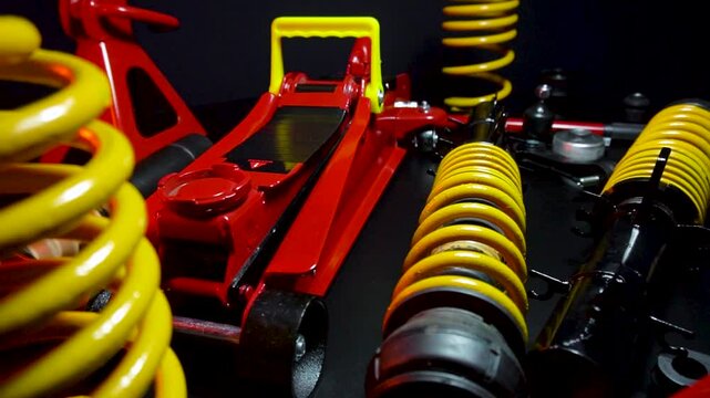 tuned new parts spare parts for the front suspension of a front-wheel drive car ball silent blocks coilovers yellow and a jack with stands