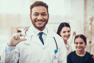 Indian doctor seeing patients in office. Doctor is posing.