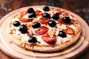 Pizza with salami and mozzarella cheese, jalapeno pepper and black olives. Wooden background. Soft focus. Close up.	
