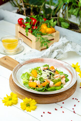 Shrimp salad with pumpkin in a plate on a white table, cafe.
