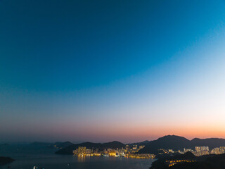Aerial panorama of Hong Kong city at twilight.  Lights illuminate the urban landscape and coastline...