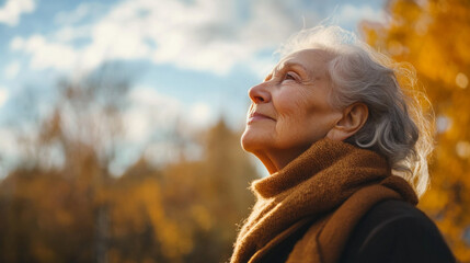 Senior woman taking a deep breath while enjoying the fresh autumn air in a tranquil park setting