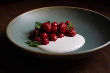 delicate mousse with caramelized strawberries and mint on a blue plate