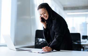 Beautiful arabian woman with abaya dress working in the office