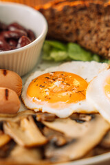 A hearty breakfast of fried eggs, sausages and toast.