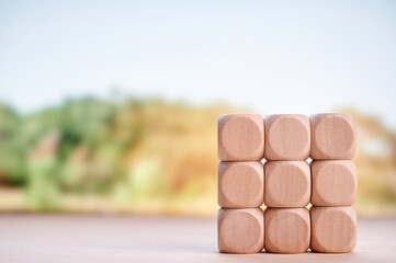 Stacked wooden blocks showcasing investment, financial planning, and growth with blurred nature-inspired background emphasizing sustainable and eco-friendly business themes