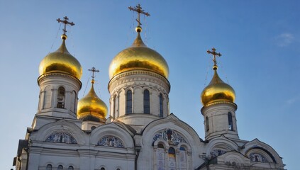 Church domes adorned with golden accents gleam brightly against a clear blue sky, showcasing intricate architectural details and historical significance during morning hours