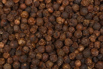 A close-up, full-frame shot of dried black peppercorns, showcasing their texture and color