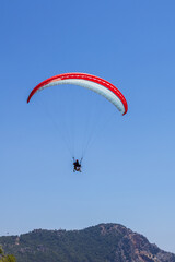 An individual is flying a parachute over a stunning mountain range
