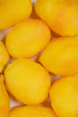 A close-up, top-down shot of several cooked yellow potatoes, revealing their texture and golden hue