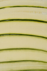 A close-up, top-down view shows several thin slices of zucchini