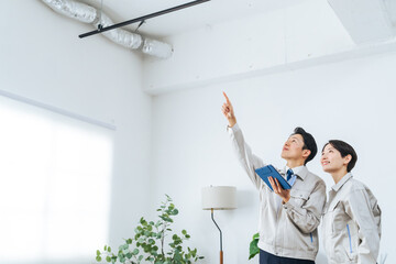 タブレットを見ながら建物を点検する作業員グループ