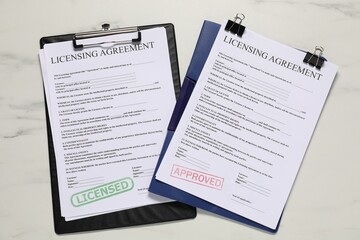 Obraz premium Licensing agreement documents on white marble table, flat lay
