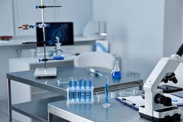 Chemical glassware and microscope on table in laboratory