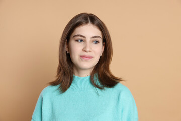 Fototapeta premium Portrait of beautiful teenage girl on beige background