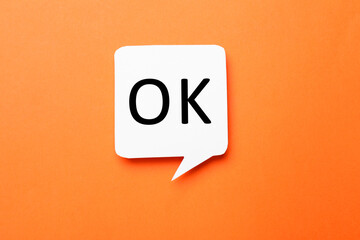 Speech bubble with abbreviation OK on orange background