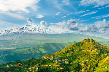 Fototapeta premium beautiful panorama of Etna vulcano in Italy, Sicily, Taormina to mountain landscape with white snow peak and green hills and valleys arround