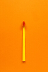 morning and evening routine dental care from caries tool like yellow toothbrush on orange background