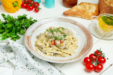 Pasta with chicken and mushrooms in creamy sauce, restaurant. Horizontal frame.