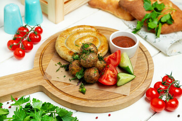 Chicken sausages with vegetables on a wooden board, restaurant. Horizontal frame.