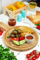 Chicken sausages with vegetables on a wooden board, restaurant. Vertical frame.