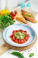 Burrata cheese with tomatoes on a plate, restaurant. Vertical frame.